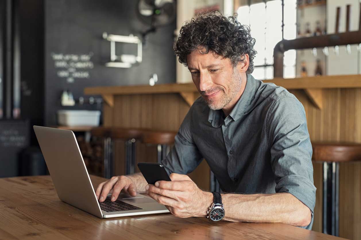 Man Checking Phone and Laptop - Think Outside theDating Screen