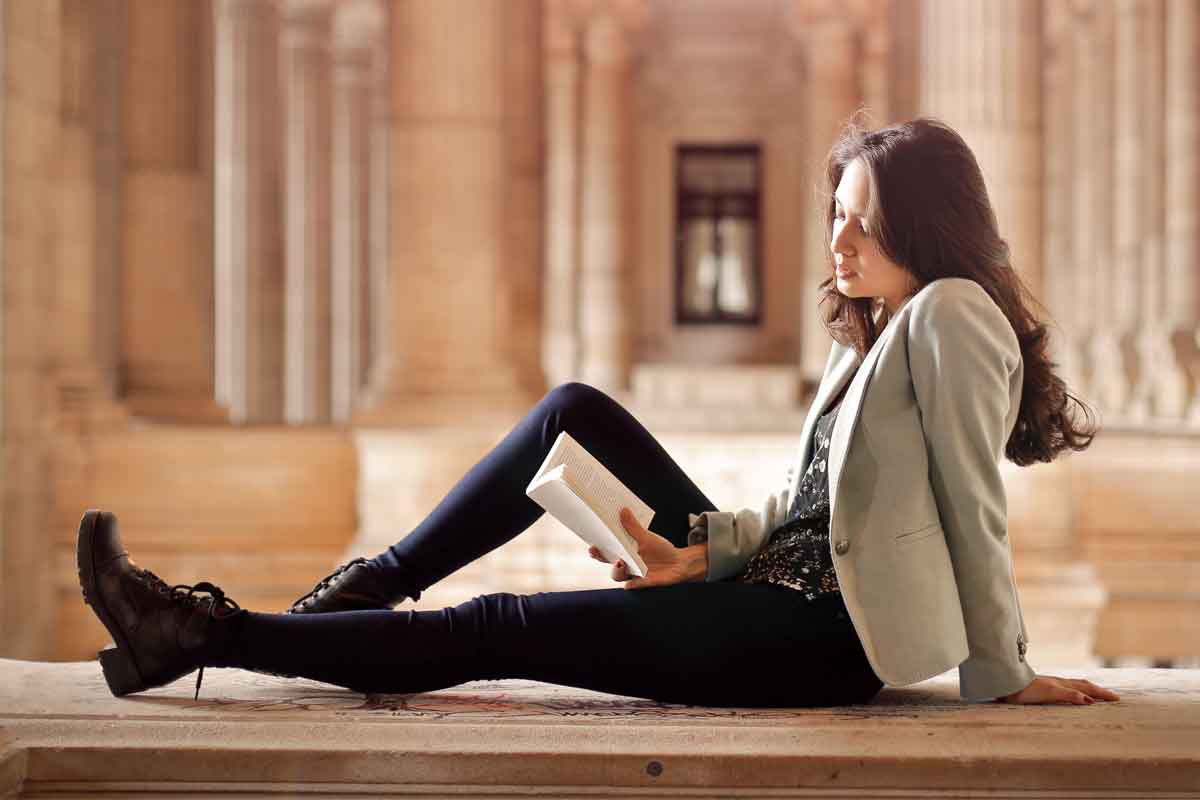 Woman Reading Dictionary of Dating at Museum