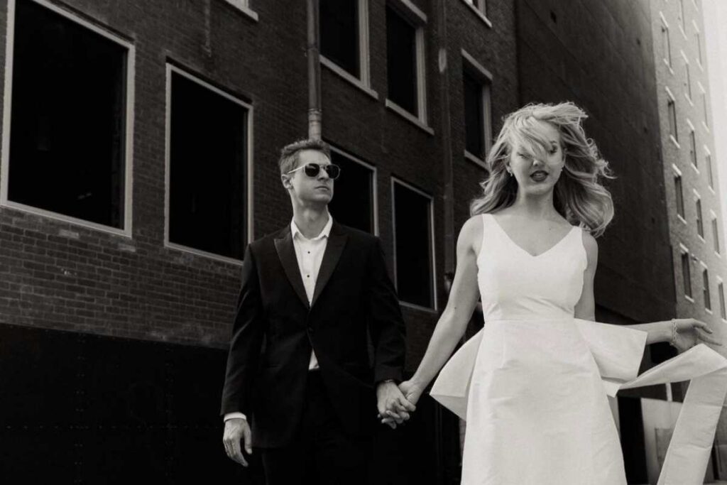 Engaged couple in city holding hands.