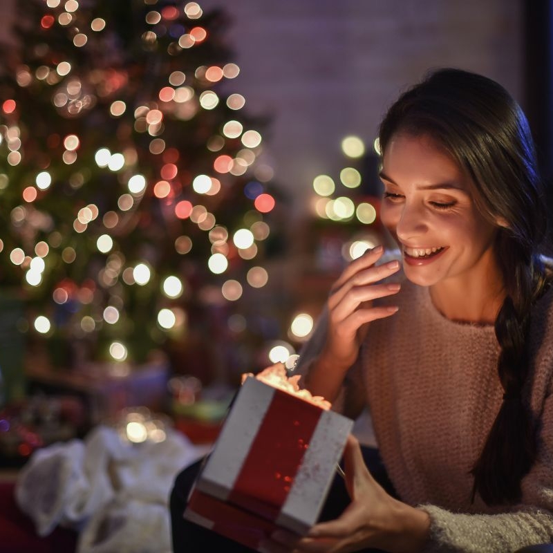 Happy woman opening Christmas gift box