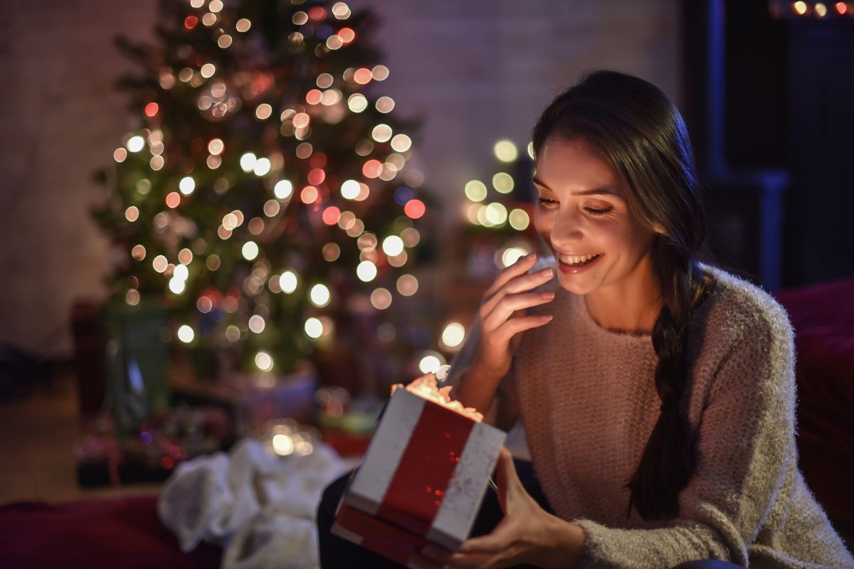 Happy woman opening Christmas gift box