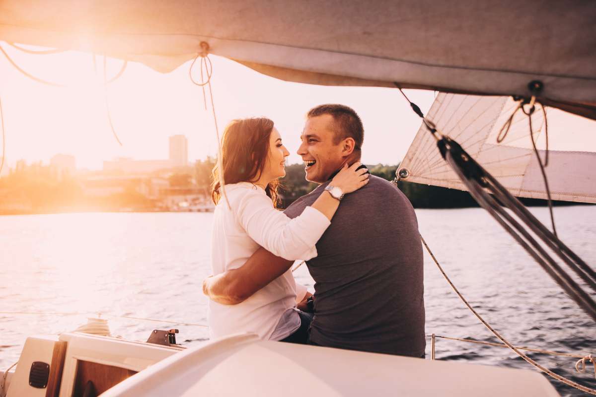 couple on the back of a boat laughing and holding each other