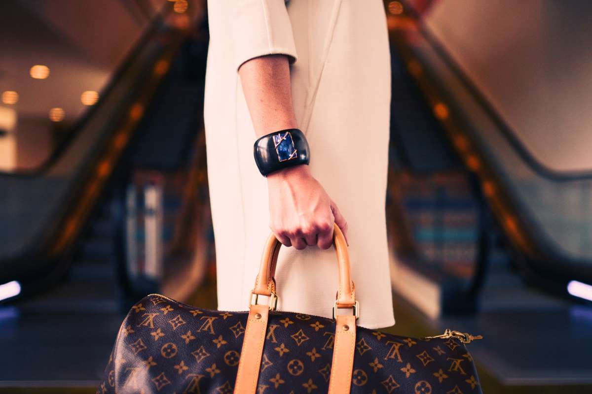 woman carrying designer duffle bag