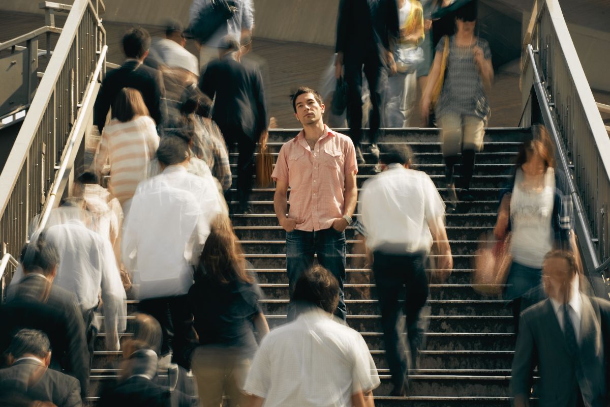 Single man standing in the middle of a crowd