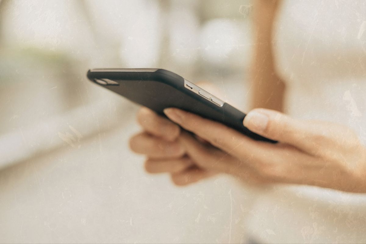 a person's hands as they hold their phone wondering if raya and other luxury dating apps are worth it