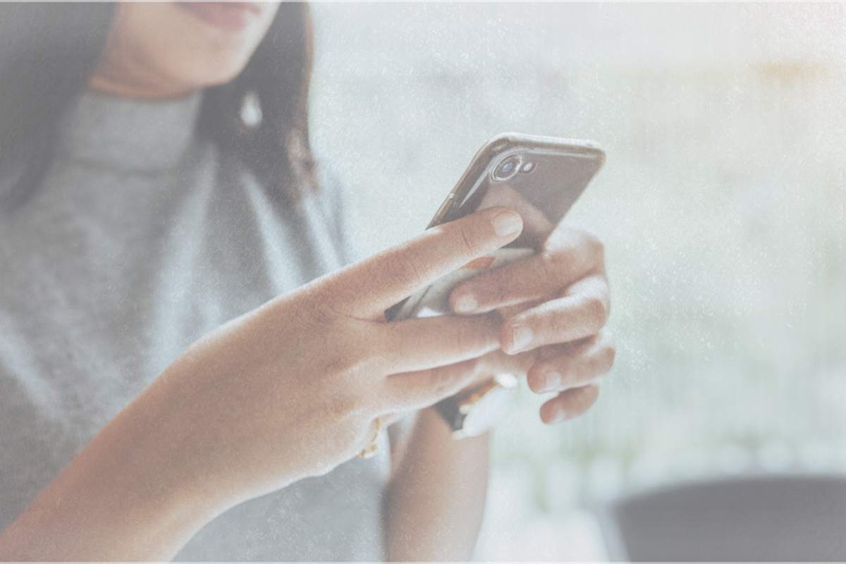 a woman looks at her phone wondering how to be better at flirting over text
