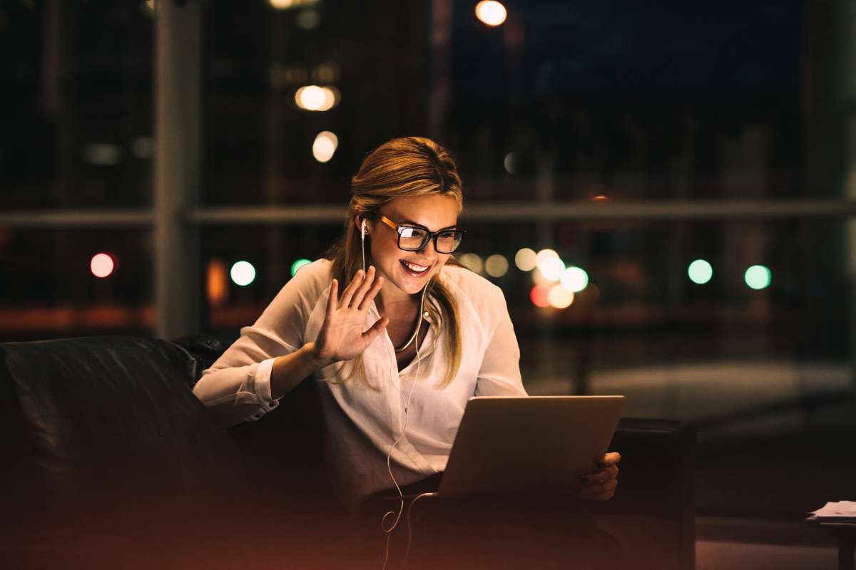 woman using headphones and computer to video chat