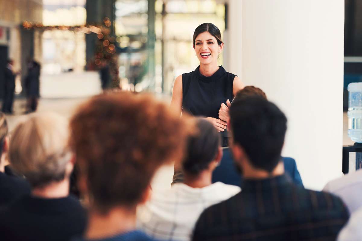 woman standing in front of small crowd of business people