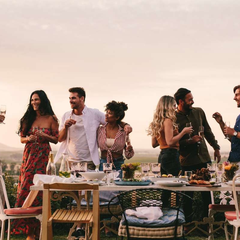 group of friends having an outdoor dinner with wine and conversation