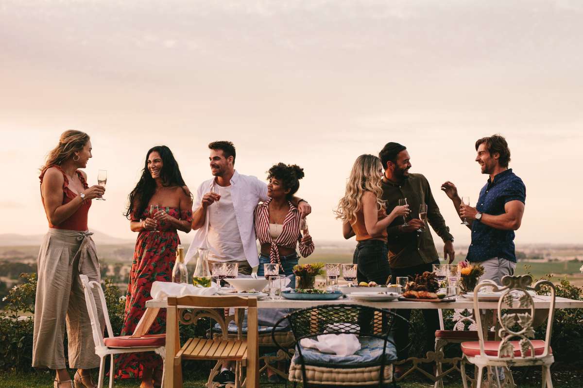 group of friends having an outdoor dinner with wine and conversation