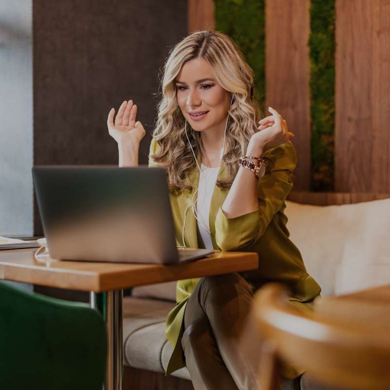 middle aged woman sitting in upscale lobby while working on her computer