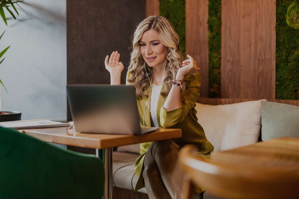 middle aged woman sitting in upscale lobby while working on her computer