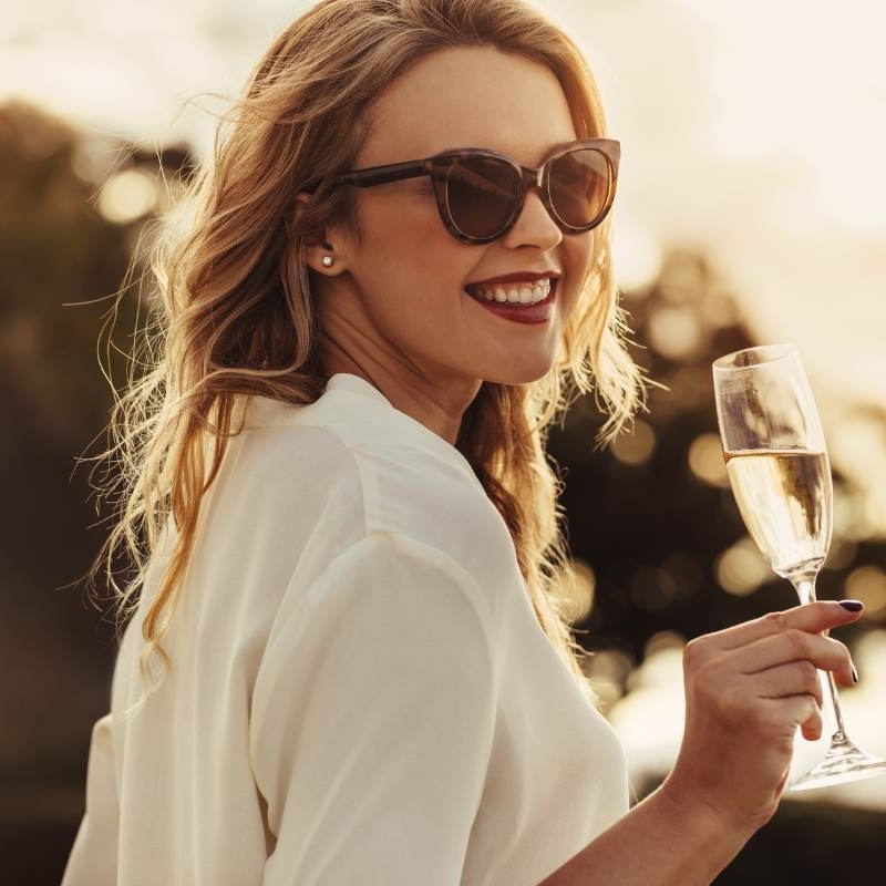 a beautiful woman holding a glass of champagne. this is the happiness that comes with choosing a partner who complements you.