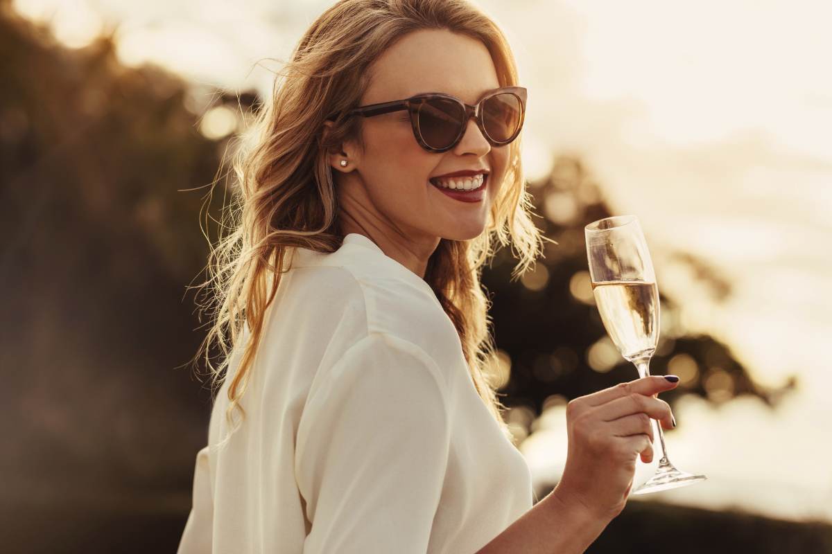 a beautiful woman holding a glass of champagne. this is the happiness that comes with choosing a partner who complements you.