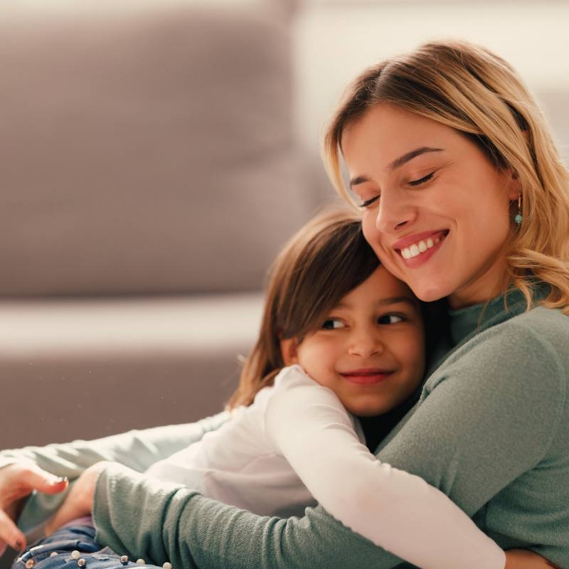 A woman holding her child in her lap. She is thriving as a single parent with a career.
