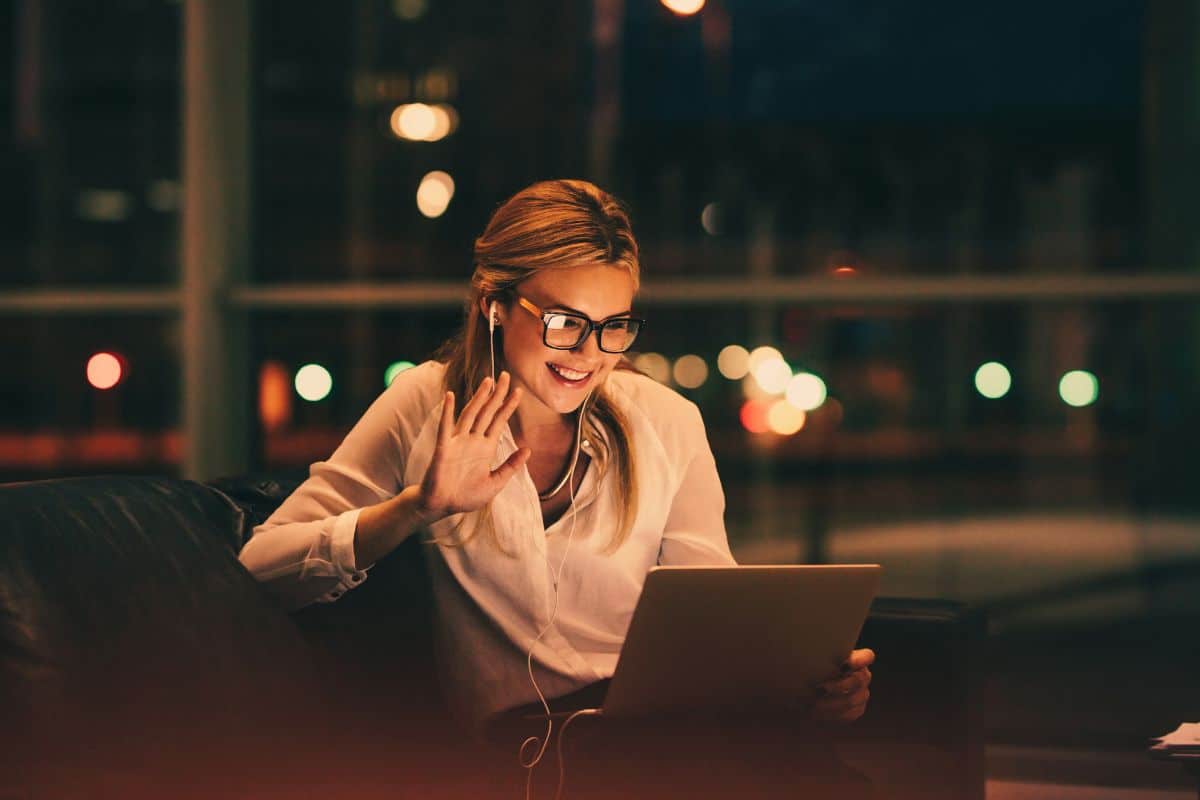 Professional female waving hello to a person on a zoom call on her laptop